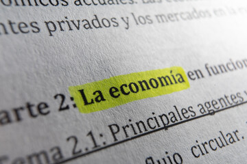 Macro Photo Close-up: Book with the Word 'La economía' Highlighted with Fluorescent Marker