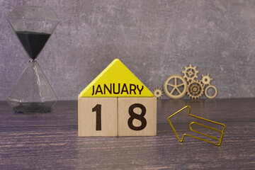 Cube shape calendar for January 18 on wooden surface with empty space for text.