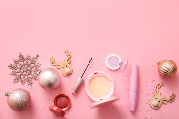 Makeup products and Christmas decor on pink background