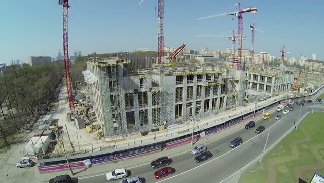 Cars ride by road near building site of city block VTB Arena Park