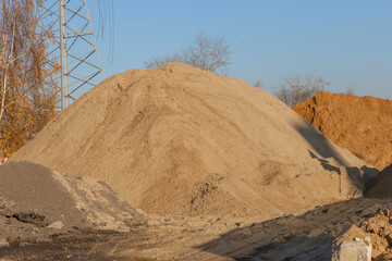 Few piles of sand on a construction site. Construction of a new road, repair of a roadway or laying...