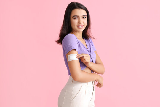 Young woman with birth control patch on pink background