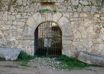 Arched gateway with iron bars which can be seen through
