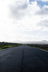 Empty asphalt highway with fields on the background