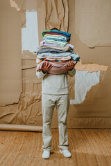 Unrecognizable man holding clothes over craft paper background