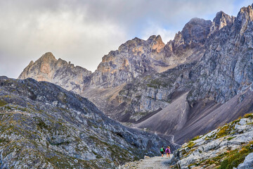 Picos de Europa National Park. To the right couple hikers walking. In Fuente de, Cantabria, Spain.