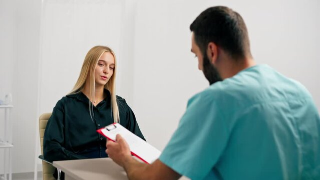 A doctor at a medical center shows girl patient her tests and prescribes further treatment