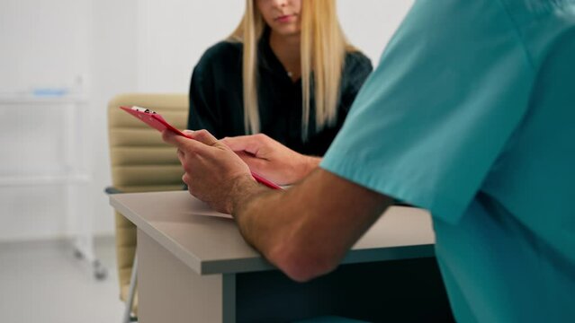 A doctor at a medical center shows girl patient her tests and prescribes further treatment