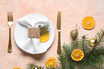 Christmas table setting with dried orange slices, fir branches and balls on beige background