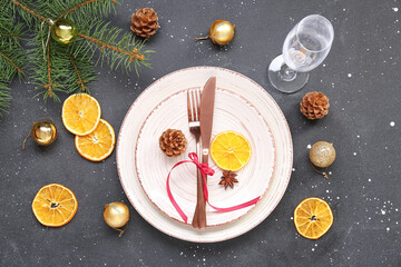 Christmas table setting with dried orange slices, fir branches and balls on black background