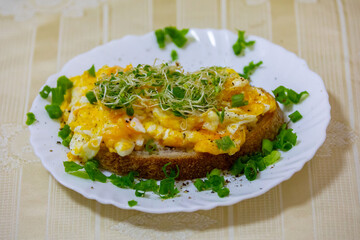 Egg bread decorated with chives and fresh alfalfa sprouts