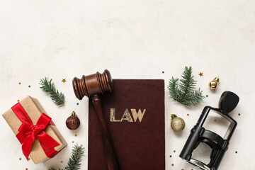 Composition with judge's gavel, law book, stamp and Christmas decorations on light background