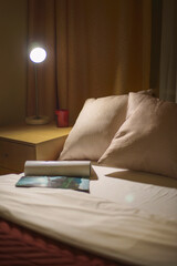 Fototapeta na wymiar bed in a hotel. bed in a bedroom. lamp in the house living room at the night before sleep. comfort apartment with soft pillow and bed. interior and design. sofa in hotel. budget hostel bedroom. guest