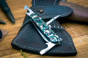 Camouflage pocket knife with military props - obrazy, fototapety, plakaty