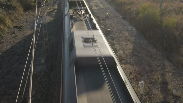 Passenger train passing and moving away at sunset