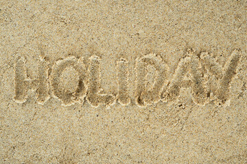 Holiday handwritten text on sand