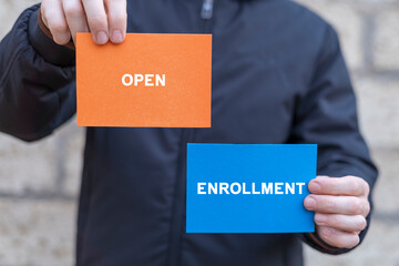 Man holding multi-colored paper cards sees inscription: OPEN ENROLLMENT. Open Enrollment Medicine Business concept. Open Enrollment 2024.