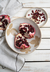 Fresh Opened Pomegranate on Light Colored Plate - 695129330