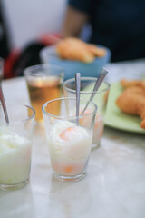 Soft boiled eggs in the glass eat with with seasoning sauce and ground pepper; Thai breakfast vintage style.