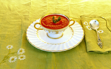 Tomato soup in a white and gold bowl