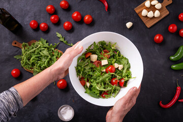 Top view of prepared fresh vegetable salad with mozzarella cheese with ingredients, flat lay
