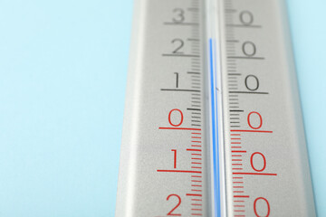 Weather thermometer on light blue background, closeup. Space for text