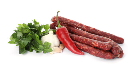 Thin dry smoked sausages and different spices isolated on white