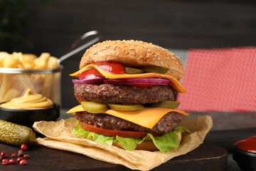 Delicious burger with meat cutlets, cheese, pickled cucumbers and lettuce on table, closeup