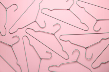 Many hangers on pink background, flat lay