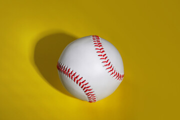 One baseball ball on yellow background, top view