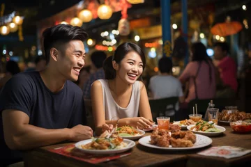 Poster Asian couple enjoying with food at night market, Traveler enjoy eating on the street food © sirisakboakaew