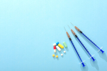 Needle cartridges and tablets on a blue background