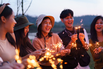 Happy men and women enjoy playing a sparklers firework in a party.