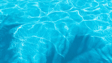 Surface of blue swimming pool. Background of water in swimming pool. Palm shadow on pool water.