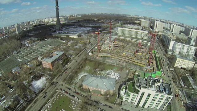 Cityscape with traffic near TV tower and construction site