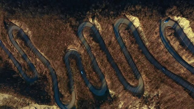 Curvy Road Concept: Aerial video of a scenic, S-shaped road full of curves, filmed by a drone in the fall. Emilia-Romagna, Italy