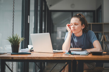 Overworked businesswoman suffering from headache and thinking how to end work.