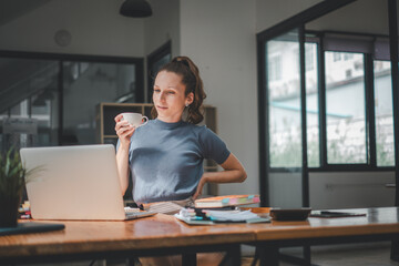 Business woman working hard in the office having aches and pains in her torso and waist.