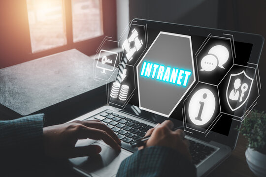 Intranet concept, Business woman using laptop computer on office desk with intranet icon on virtual screen, sharing information, collaboration tools, and other computing services.
