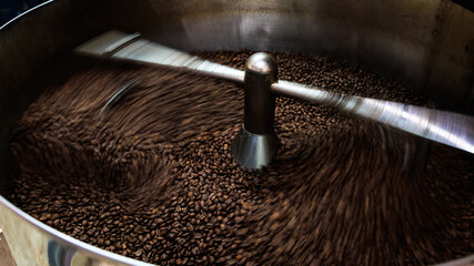 coffee beans and roasted spinning cover professional machine, close up to soft focus, take low speed photo to need movement and coffee beans detail concept,.