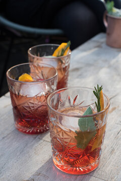 Three spritz cocktails on a marble table