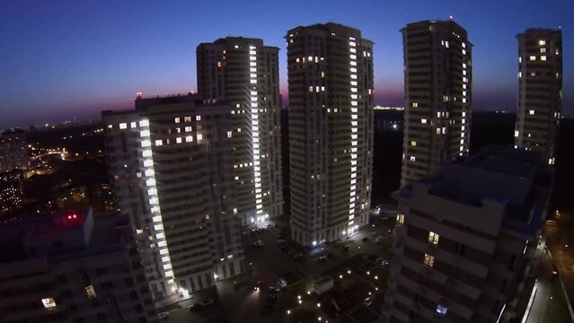 Houses of residential complex against cityscape at evening