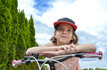 Naklejka premium Young girl cyclist enjoy the beautiful sunrise on summer forest trail