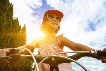 Young girl cyclist enjoy the beautiful sunrise on summer forest trail