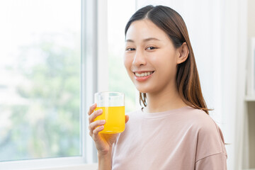 Smile asian young woman, girl hand holding a glass of water after putting or dropping yellow...