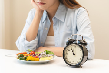 Intermittent fasting with clock, close up young woman, girl diet, waiting time to eat ketogenic low...