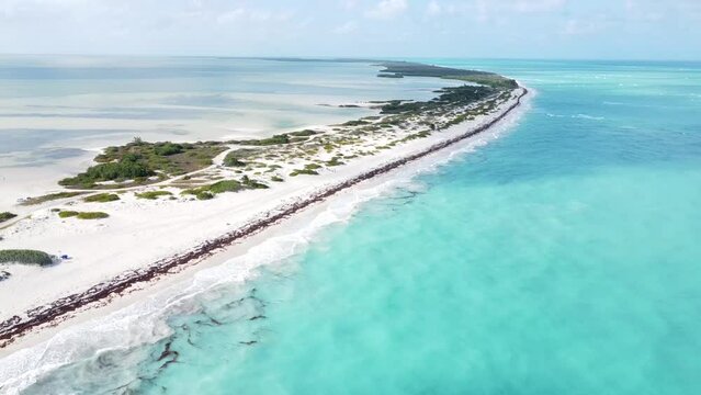 Aerial of Isla Blanca, Mexico, perpetual ebb and flow of the ocean. The azure and turquoise hues stretch as far as the eye can see. Traveling and vacation concept.