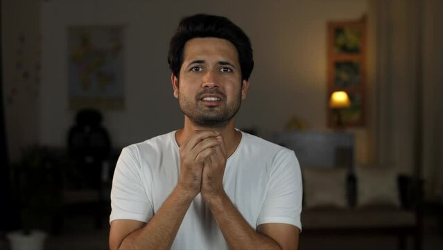 A young shocked Indian man looks at the camera - shocked expression  Brown man  over acting  loud expressions  giving reactions. People emotions concept: Asian man watching horror movie  Indian tee...