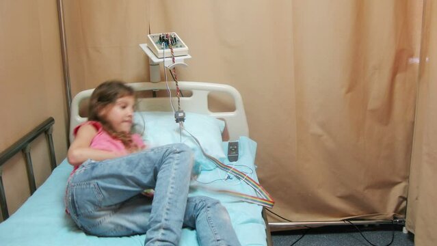 The doctor puts the girl cap with electrodes , epilepsy EEG test