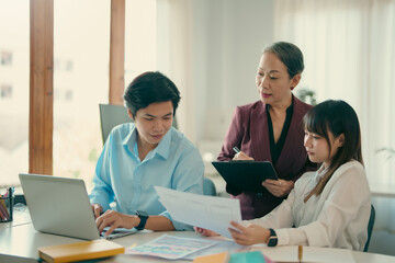 Group of asian designer talking and development ux app on mobile phone during the meeting in office.
